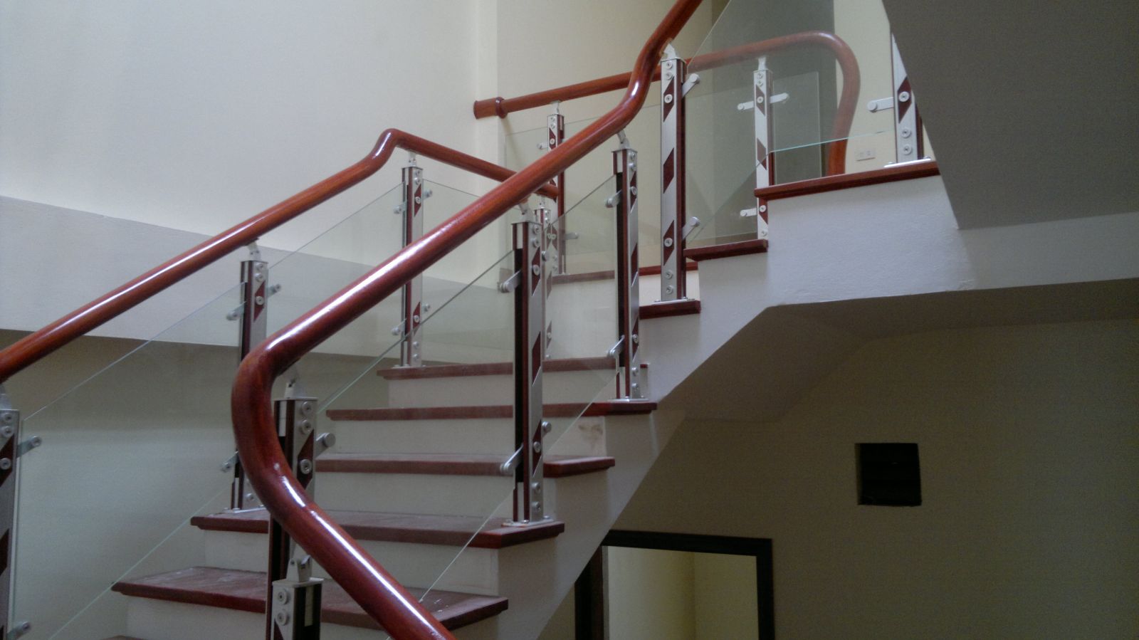 Cầu thang kính tay vịn gỗ hiện đại tại Hải Phòng